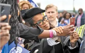  ?? AP PHOTO/GEORGE WALKER IV ?? Oprah Winfrey takes selfies with family and guests of graduates during the Tennessee State University Commenceme­nt ceremony Saturday in Nashville.