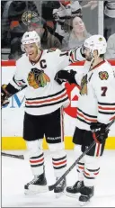  ?? JIM MONE/ THE ASSOCIATED PRESS ?? Chicago center Jonathan Toews, left, celebrates one of his three goals with Brent Seabrook during the third period against Minnesota on Tuesday in St. Paul, Minn. The Blackhawks won 5-3.