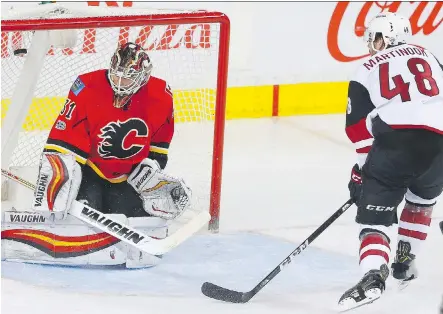  ?? AL CHAREST ?? Arizona’s Jordan Martinook scores on Flames goalie Chad Johnson Monday during the Coyotes’ 5-0 victory at Scotiabank Saddledome.