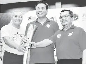  ?? — Gambar Bernama ?? SIMBOLIK: Tey (tengah) bersama Rabuan (kiri) memegang Obor Asia Pacific Masters Games 2018 pada Majlis Penyerahan dan Penerimaan Obor berkenaan semalam.