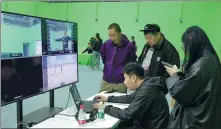  ?? ?? Left: Director Cao Liang (center sitting) edits images using specialize­d software. The images are captured from motions of wired-up actors.