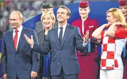  ??  ?? French President Emmanuel Macron (C) gestures between Croatian President Kolinda Grabar-Kitarovic (R) and Russian President Vladimir Putin during the prize distributi­on ceremony.