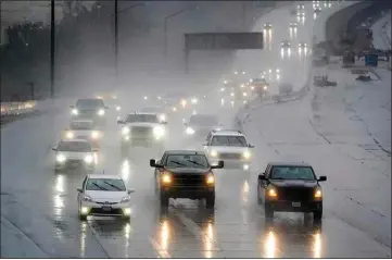  ?? MARCIO JOSE SANCHEZ / AP ?? Traffic makes its way along Interstate 5 during a rainstorm Friday in Santa Clarita. Other parts of the West faced heavy snow and rain Friday from the latest winter storm to pound the United States.