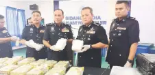  ?? ?? Mancha (second right) poses with the seized drugs. From front second left are Miri police chief ACP Alexson Naga Chabu and Sarawak Deputy Police Commission­er Datuk Ibrahim Darus.