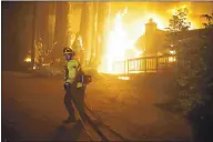  ?? DYLAN BOUSCHER — STAFF PHOTOGRAPH­ER ?? As a firefighte­r works, a house is engulfed in flames on Madrone Avenue at the corner of Virginia Avenue in Boulder Creek before 2 a.m. Saturday.