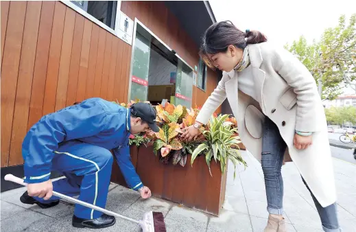  ??  ?? Above: Li Ying checks up on work outside a public toilet on Hutai Road. Li is now responsibl­e for 43 public toilets, 20 of which — including the one where she first worked — are being upgraded into “smart public toilets.” Below: Li’s toilet on Hutai Road has become a model of cleanlines­s with air conditioni­ng and mobile phone chargers. — All photos by Jiang Xiaowei