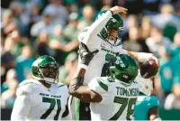  ?? ?? Jets quarterbac­k Zach Wilson celebrates with guard Laken Tomlinson after scoring a touchdown in the second quarter against the Dolphins on Sunday.