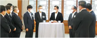  ?? Yonhap ?? President Moon Jae-in speaks with company CEOs of electric vehicle, semiconduc­tor and shipbuildi­ng industries during their meeting at Cheong Wa Dae, Thursday.