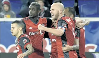  ?? BILL KOSTROUN/THE ASSCOIATED PRESS ?? Toronto FC midfielder Michael Bradley celebrates a goal by Victor Vazquez, rear right, during the first half of an MLS Eastern Conference semifinal soccer match against the New York Red Bulls, on Monday, in Harrison, N.J.