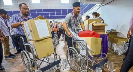  ??  ?? Crunch time: EC staff making final preparatio­ns for polling day at the vote tallying centre at dewan datuk Sri Panglima Mohd dun Banir in Beaufort.