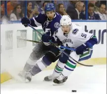  ?? The Associated Press ?? Vancouver Canucks defenceman Troy Stecher and Tampa Bay Lightning centre Cedric Paquette chase a loose puck during the second period of an NHL game on Thursday in Tampa, Fla. Jayson Megna and Jack Skille both had two goals as the Canucks beat the...