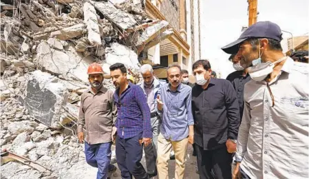  ?? IRANIAN SENIOR VICE-PRESIDENT OFFICE VIA AP ?? Vice-President Mohammad Mokhber (second from right) on Friday tours the site of the tower that collaped in Abadan, Iran, last week, killing 32. An emissary sent by Iran’s government was shouted down and booed on Sunday as he tried to address mourners.