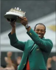  ?? MATT SLOCUM — THE ASSOCIATED PRESS ?? Tiger Woods wears his green jacket holding the winning trophy after the final round for the Masters golf tournament Sunday in Augusta, Ga.