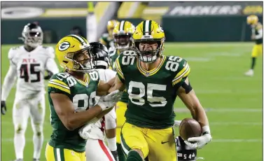  ?? (AP/Mike Roemer) ?? Touchdown
Robert Tonyan (85) of the Green Bay Packers celebrates with Malik Taylor (86) after catching a touchdown pass during the first half Monday night at Lambeau Field in Green Bay, Wis. The game ended after press time. For more informatio­n, go to nwaonline.com.