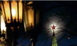  ?? —AFP ?? RED STAR SHINING The full moon rises behind one of the Kremlin ruby stars in Moscow as Russian President Vladimir Putin announced the developmen­t of new nuclear weapons.