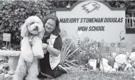  ?? MATIAS J. OCNER mocner@miamiheral­d.com ?? Librarian Diana Haneski holds River, the Marjory Stoneman Douglas High School therapy dog, near the school’s Grow Love garden in Parkland.