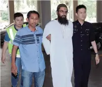  ?? AP ?? Danish national Salah Salem Saleh Sulaiman, escorted by police, arrives at a court house in Kuala Lumpur on Monday. —