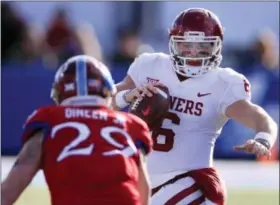  ?? ORLIN WAGNER — THE ASSOCIATED PRESS ?? Oklahoma quarterbac­k Baker Mayfield (6) tries to avoid Kansas linebacker Joe Dineen Jr. (29) during the first half of an NCAA college football game in Lawrence, Kan., Saturday.