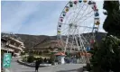  ?? Kohsar/AFP/Getty Images ?? Taliban guards standing watch next to an empty ferris wheel ride at the Zazai Park on the outskirts of Kabul. Photograph: Wakil