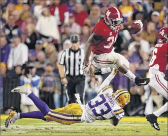  ?? Gerald Herbert / Associated Press ?? Alabama running back Damien Harris leaps over LSU safety Todd Harris Jr. on a carry in the first half of their game Saturday. Harris gained 107 yards on 19 carries.