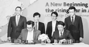  ??  ?? UOB Vietnam chief executive officer Harry Loh and VSIP JV’s Deputy General Director Anthony Tan sign the MOU to cement both companies’ commitment to encourage FDI into Vietnam.The signing was witnessed by (from left) UOB head of group wholesale banking Frederick Chin, Foreign Investment Agency of Vietnam Director General Do Nhat Hoang, Enterprise Singapore regional director Koh Chong Yu, and VSIP JV chief financial controller Sean Lim.