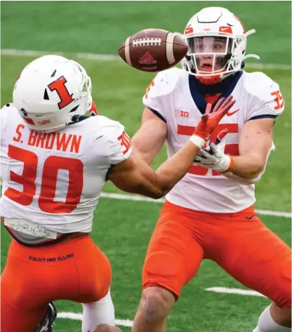  ?? NATI HARNIK/ AP ?? Illini linebacker Jake Hansen ( 35) snags an intercepti­on as he and safety Sydney Brown follow the bouncing ball.