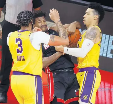  ?? KEVIN C. COX/GETTY ?? Anthony Davis and Danny Green of the Lakers defend Jimmy Butlerof the Heat during the fourth quarter of Game 4 on Tuesday.