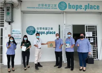  ??  ?? Socso Sarawak director Phillip Sangkan (third right) hands over a drop box to Wan during a courtesy visit to Hope Place’s headquarte­rs in Kuching.