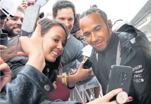  ??  ?? Mercedes driver Lewis Hamilton, right, poses for photos with his fans in Mexico City.