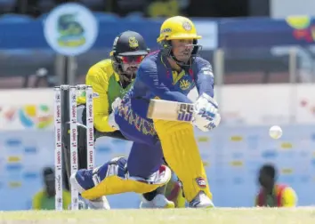  ?? (Photos: CPL via Getty Images) ?? Quinton de Kock (right) of Barbados Royals reverse sweeps for four as wicketkeep­er Amir Jangoo of Jamaica Tallawahs looks on during the Hero Caribbean Premier League match at Daren Sammy National Cricket Stadium in Gros Islet, St Lucia, on Sunday.