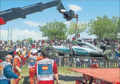  ?? LLIBERT TEIXIDÓ ?? La grúa se lleva el monoplaza accidentad­o de Lewis Hamilton