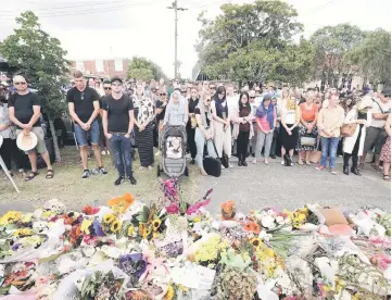  ??  ?? Local residents with head scarfs gather for the call to prayer and the moments silence at Masjid Umar mosque in Auckland, a week after the Christchur­ch twin mosques attacks that claimed 50 lives.