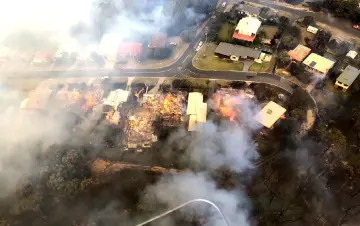  ??  ?? This handout aerial picture shows homes burning in the fires which devastated the seaside town of Tathra. — AFP photo