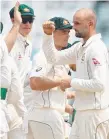  ??  ?? Nathan Lyon (right) celebrates a wicket last night.