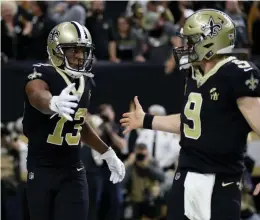  ?? / AFP ?? Drew Brees (9) choca la mano con Michael Thomas.