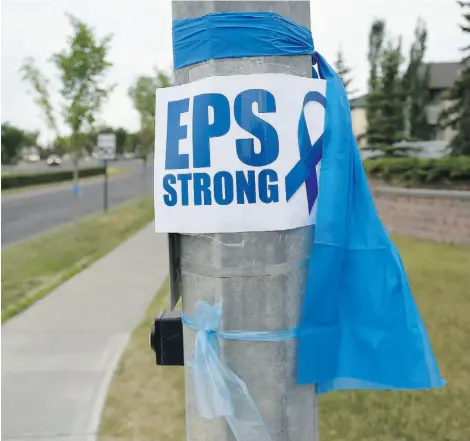  ?? John Lucas/Edmonton Journal ?? Blue ribbons line the streets of Edmonton’s Terwillega­r neighbourh­ood on Thursday to honour slain Const. Daniel Woodall.