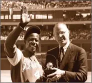  ?? (AP file photo) ?? Baseball commission­er Bowie Kuhn (right) presents Hank Aaron with a trophy on April 4, 1974, after Aaron tied Babe Ruth’s alltime home run record with his 714th homer in Cincinnati. Aaron went on to hit 755 home runs, second on the all-time list behind Barry Bonds, who hit 762.