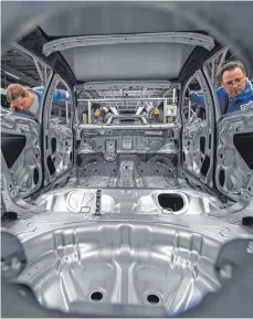  ?? FOTO: DPA ?? Karosserie­n des VW Golf 7 werden im Werk Zwickau montiert. Klagen in den USA haben Volkswagen bereits etliche Milliarden gekostet.