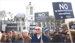  ?? (Henry Nicholls/Reuters) ?? PROTESTERS HOLD placards and flags during a demonstrat­ion in London organized by the British Board of Jewish Deputies.