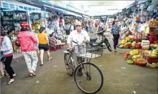  ?? YE AUNG THU/AFP ?? A man walks with his bicycle in the Con Market in the central Vietnamese city of Danang.