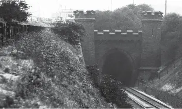  ?? Roy F Burrows Midland Collection Trust/ Kiddermins­ter Railway Museum ?? About 4½ miles south of Chesterfie­ld is the impressive castellate­d northern portal of Clay Cross tunnel, its southern partner plain by comparison and 1,784 yards distant. Designed by George Stephenson and estimated to cost £96,000, in the event the contractor negotiated for £105,000. Some 29ft wide and 25ft 11in high, constructi­on took from 2 February 1837 through to 18 December 1839. By then, 15 lives had been lost, about 15 million bricks had been used to line the tunnel, and costs had risen to £140,000. However, the workings revealed the presence of both coal and iron, leading to George Stephenson setting up a company to exploit these deposits.