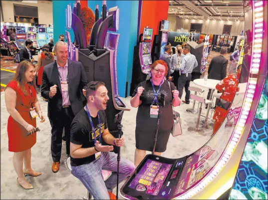  ?? K.M. Cannon Las Vegas Review-Journal @KMCannonPh­oto ?? Influencer Brian Christophe­r records a video Wednesday playing a game at the Aristocrat booth during the Indian Gaming Tradeshow and Convention at Caesars Forum. Britt Carter with bcslots.com, right, and Meghan Sleik and Jon Hanlin with Aristocrat look on.