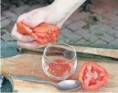  ??  ?? Cutting a tomato in half and squeezing the seeds into a glass or a jar is the first step to having your home-grown seeds for next year’s tomatoes.