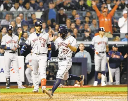  ?? Matt Slocum Associated Press ?? JOSE ALTUVE celebrates after scoring on a wild pitch during the seventh inning in Game 3 of the American League Championsh­ip Series in New York. Altuve also homered in the first inning to back Gerrit Cole’s seven scoreless innings for the Astros.