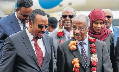  ?? /AFP ?? The path to peace: Ethiopian Prime Minister Abiy Ahmed, left, walks with Eritrea’s Foreign Minister Osman Saleh Mohammed as Eritrea’s delegation arrives for peace talks with Ethiopia at the internatio­nal airport in Addis Ababa, Ethiopia, on Tuesday.