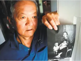  ?? Randi Lynn Beach / AP 1998 ?? Arthur Shibayama holds a photograph of his mother, sister and himself in Lima, Peru in 1932. He sought reparation­s from the U.S. for his internment.