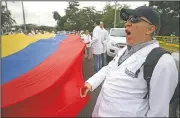  ?? AP/FERNANDO VERGARA ?? Venezuelan doctors shout slogans Sunday against the government of Venezuela’s President Nicolas Maduro at the Tienditas Internatio­nal Bridge, which has been blocked by the Venezuelan military, near Cucuta, Colombia, across the border from Tachira, Venezuela.