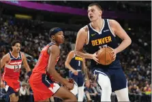  ?? DAVID ZALUBOWSKI — THE ASSOCIATED PRESS ?? Nuggets center Nikola Jokic, right, drives the lane as Wizards guard Bilal Coulibaly defends in the second half Thursday.