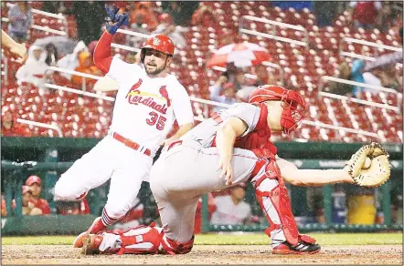  ?? (AP) ?? St Louis Cardinals’ Greg Garcia scores on a double by Matt Carpenter as Cincinnati Reds catcher Stuart Turner receives the throw during the seventh inning of a baseball game on Sept 12, at Busch Stadium in St Louis.