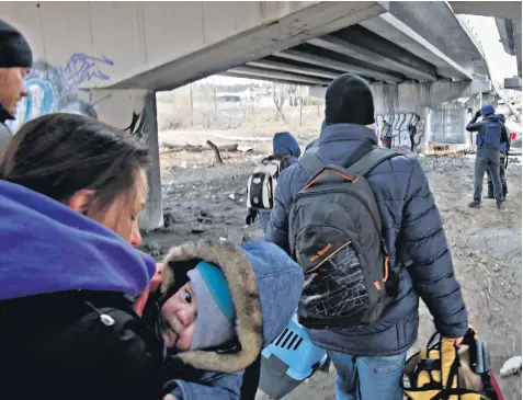  ?? ?? Residents of Irpin tried to evacuate by road but one group waved the white flag, left, and walked across open ground. Below, the young were caught up in the treks. Bottom, deaf children were evacuated in a Telegraph car from a school in Kamenskoye to Zaporizhzh­ya